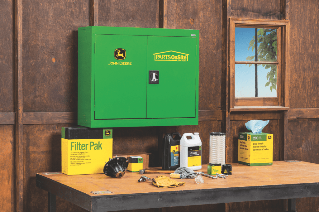 A mechanic shop setting with a John Deere Parts Onsite box and John Deere parts displayed 
